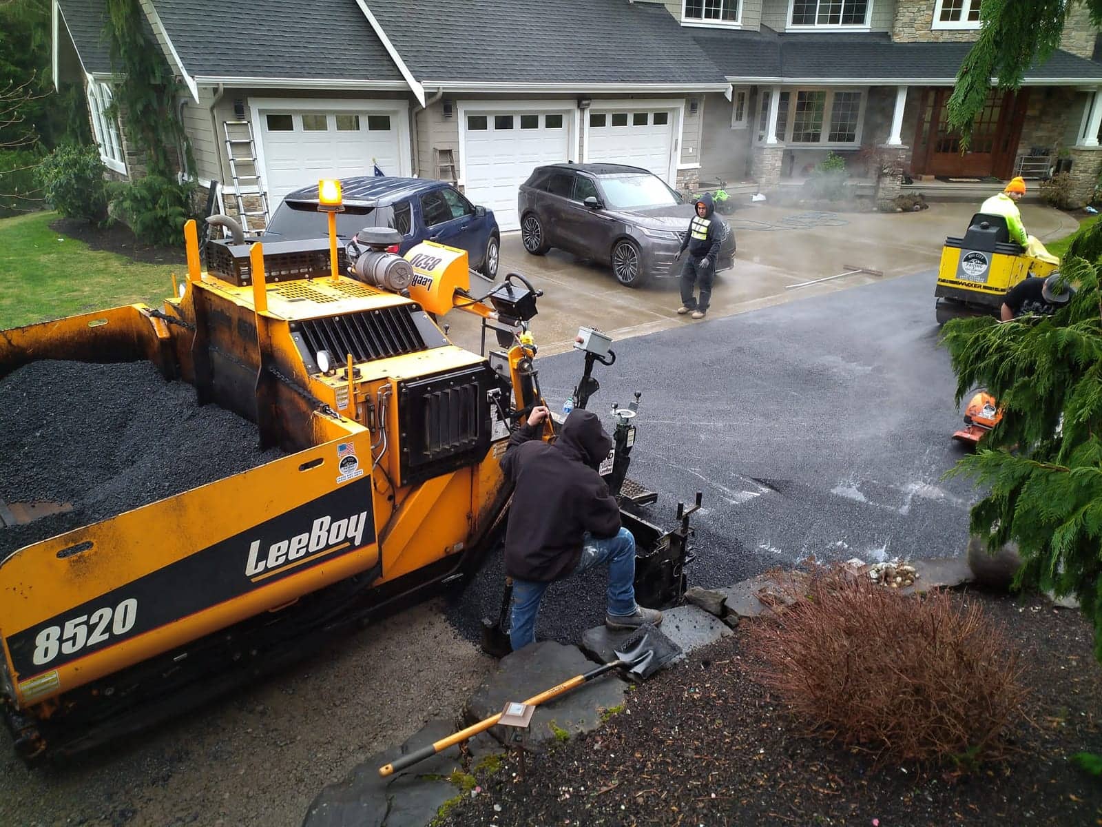 Paving crew working a driveway at a hillside home