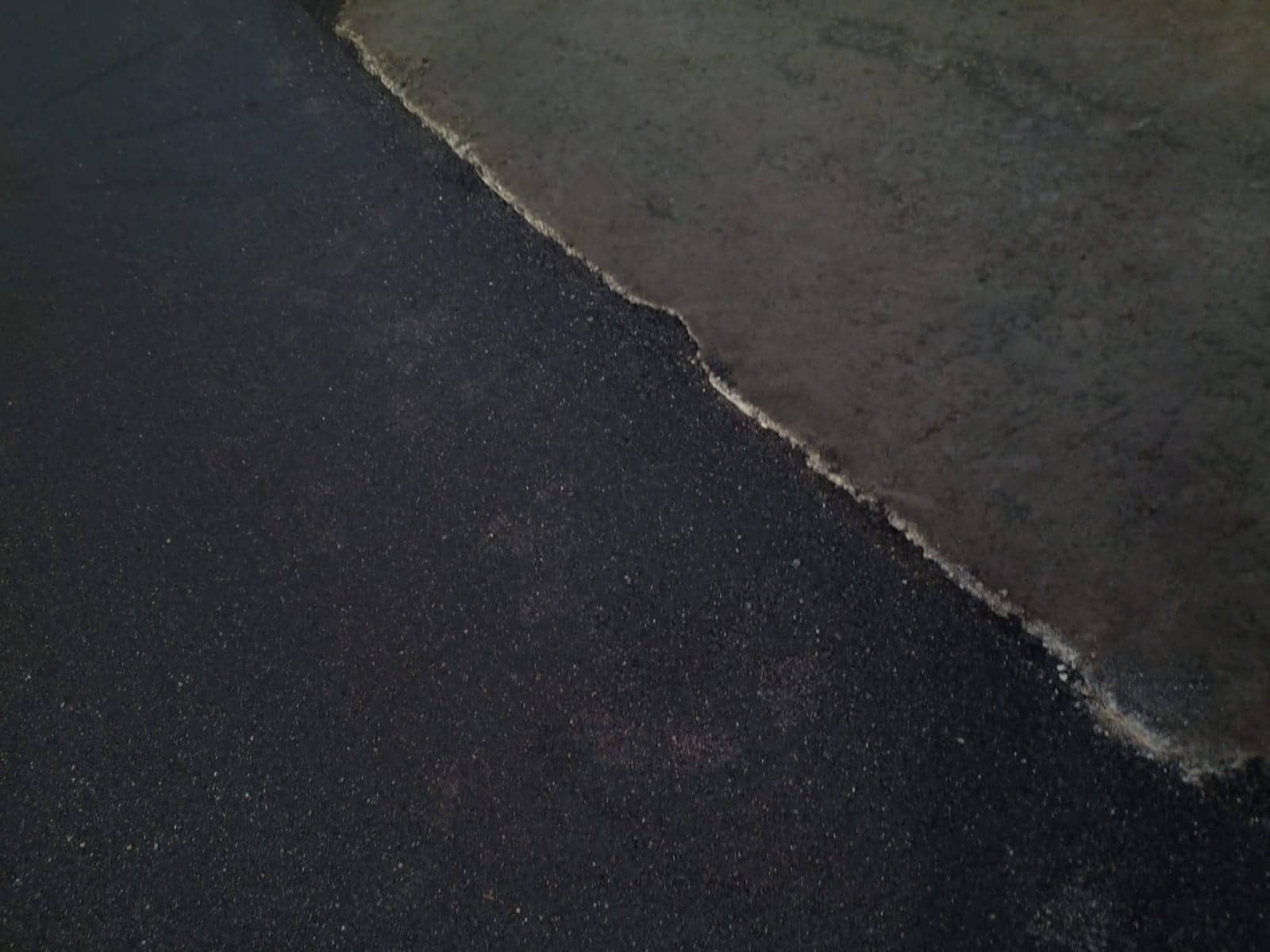 New asphalt overlay meeting the aged surface it replaces