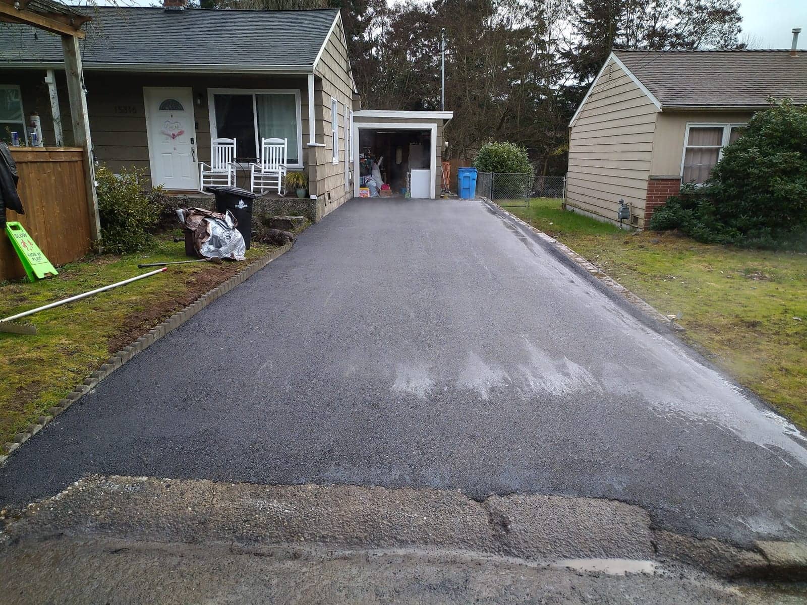 Residential driveway with a fresh, deep black asphalt finish