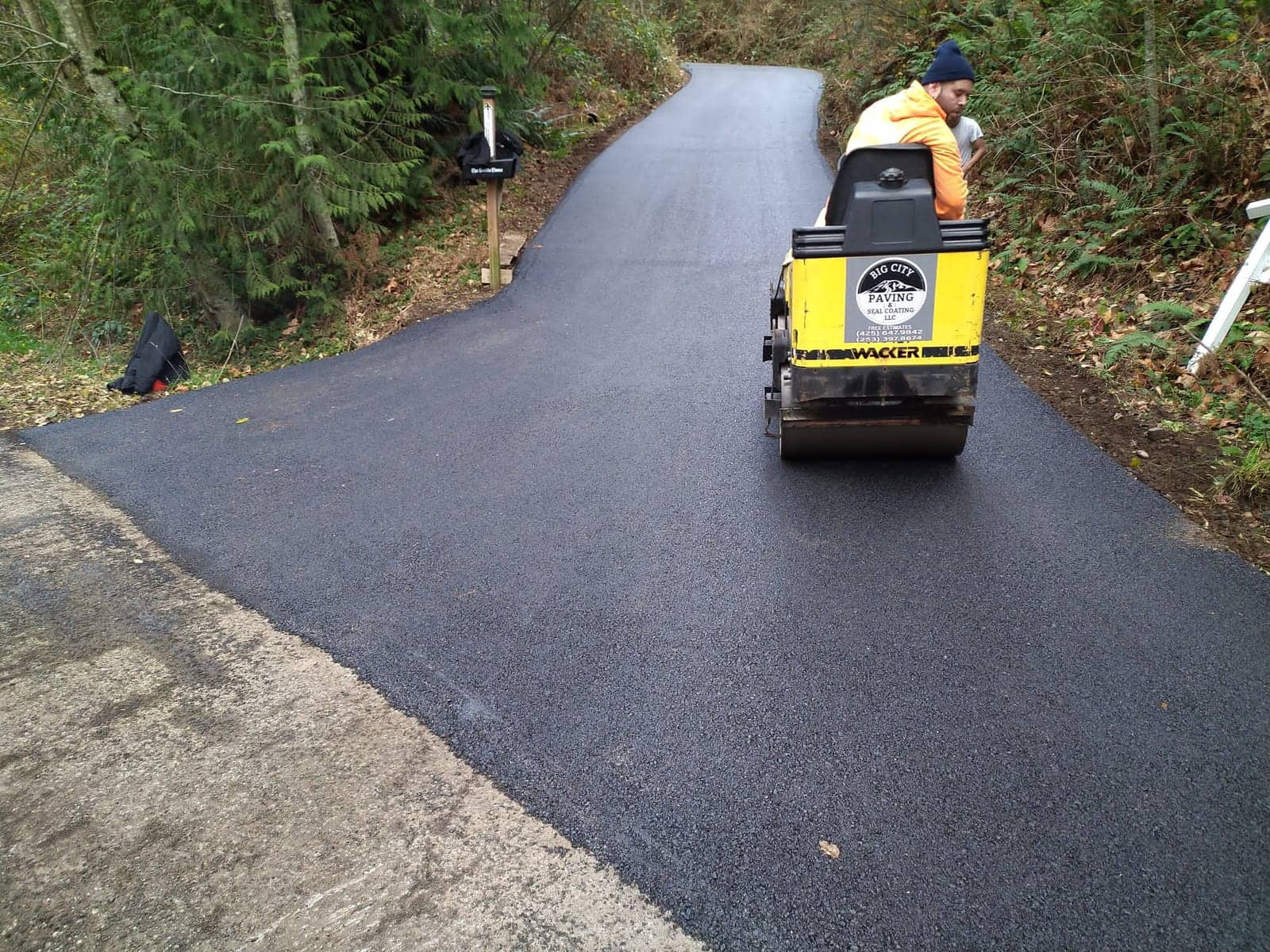 Roller compacting a freshly paved trail