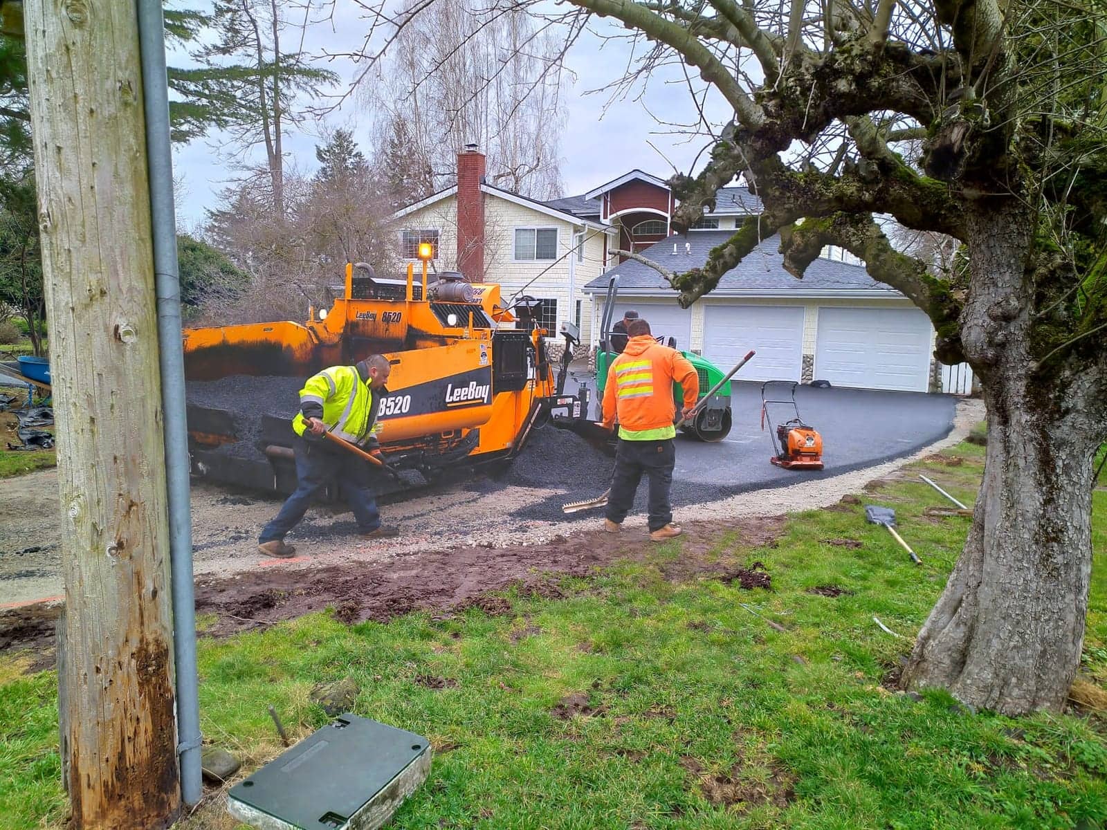 Big City Paving crew laying fresh asphalt beside the paver