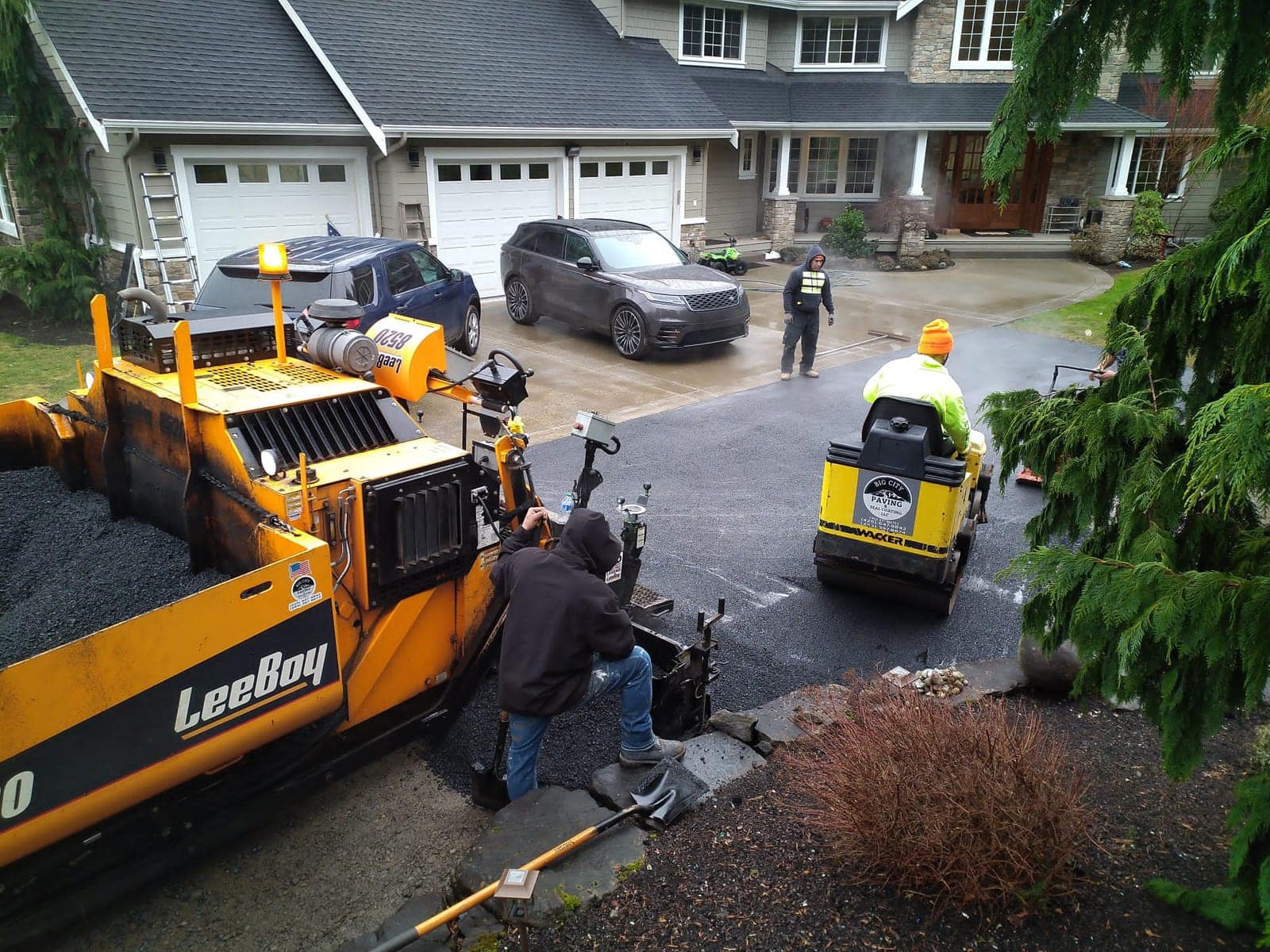 Big City Paving crew paving a new driveway at a three-car-garage home