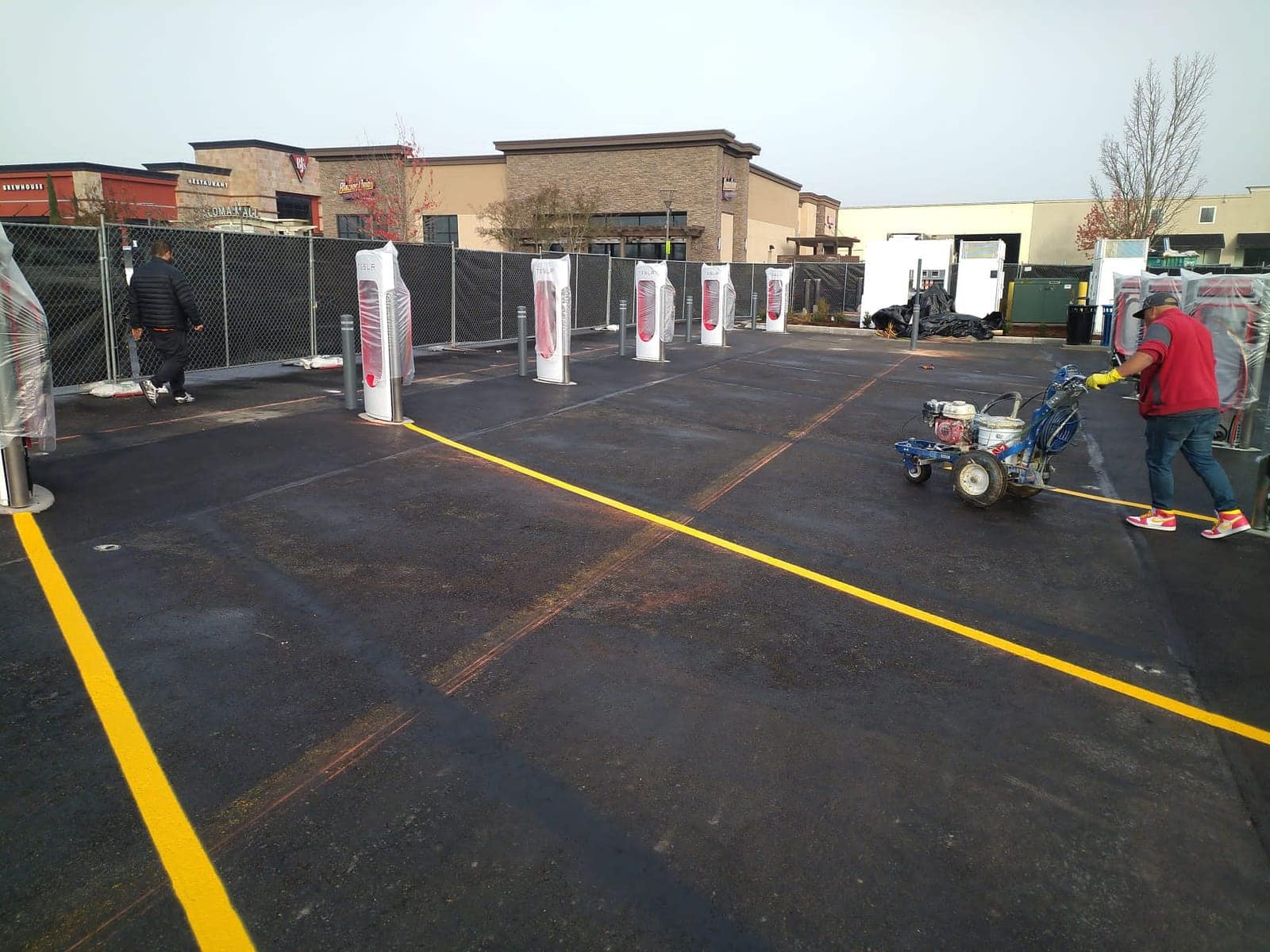 Line-striping machine laying fresh pavement markings on a commercial lot